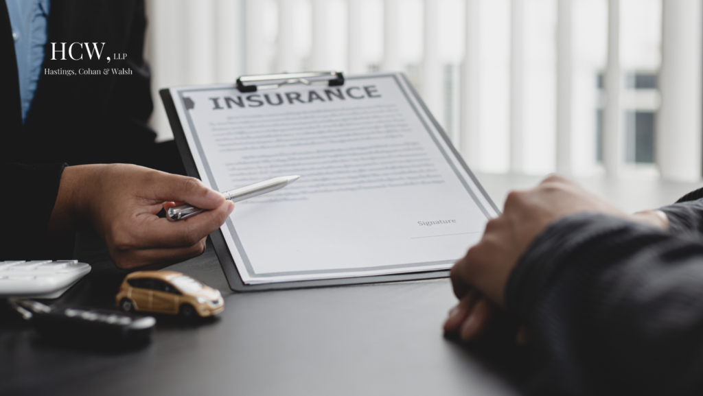 Person reviewing insurance document with agent representing uninsured motorist claims after a car accident