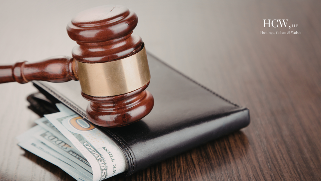 Judge’s gavel resting on a wallet filled with cash representing a personal injury settlement
